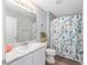 Bathroom featuring a decorative shower curtain, a single sink with a white cabinet, and a framed mirror and wall decor at 1334 Hollyberry Pl, The Villages, FL 32162