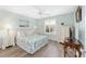 Relaxing bedroom featuring a queen bed, decorative lamps, a shuttered window, and a side table, creating a serene retreat at 1334 Hollyberry Pl, The Villages, FL 32162