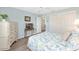 A charming bedroom with a queen bed, soft blue walls, closet and view to hallway, offering a relaxing living space at 1334 Hollyberry Pl, The Villages, FL 32162