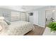 A comfortable bedroom with a queen bed, shuttered window, and a view leading to the dining room, offering a relaxing space at 1334 Hollyberry Pl, The Villages, FL 32162