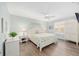 A quaint bedroom featuring a queen-sized bed, light blue walls, wood-style flooring, and a charming cottage-style decor at 1334 Hollyberry Pl, The Villages, FL 32162