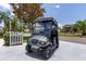 Grey Club Car golf cart parked in driveway of a well-manicured residential neighborhood at 1334 Hollyberry Pl, The Villages, FL 32162