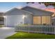 Charming single-story home with a well-maintained lawn, picket fence, and cozy screened-in porch at 1334 Hollyberry Pl, The Villages, FL 32162