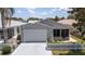Charming home featuring a two-car garage, landscaped yard, and welcoming curb appeal at 1334 Hollyberry Pl, The Villages, FL 32162