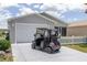 Charming single-story home with a well-maintained lawn and a golf cart parked in the driveway at 1334 Hollyberry Pl, The Villages, FL 32162