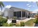 Single story home with screened in porch, outdoor patio and a two car garage at 1334 Hollyberry Pl, The Villages, FL 32162