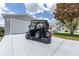 A golf cart parked in front of the garage ready for a round on the greens at 1334 Hollyberry Pl, The Villages, FL 32162