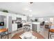 Bright kitchen features stainless steel appliances, white cabinetry and light countertops with breakfast bar open to the living room at 1334 Hollyberry Pl, The Villages, FL 32162