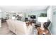 Open-concept living room featuring modern furnishings, sleek floors, and a view into the kitchen and dining areas at 1334 Hollyberry Pl, The Villages, FL 32162