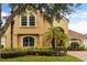 Two-story home with mature landscaping, arched entryway, and brick driveway at 1444 Whitney Isles Dr, Windermere, FL 34786