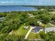Stunning aerial view of a lakeside home nestled among lush trees with a long driveway and separate guest house at 16615 Oklahoma St, Clermont, FL 34715