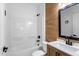 Bathroom featuring tub and shower combination, wood accent wall, and modern vanity at 16615 Oklahoma St, Clermont, FL 34715