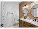 Modern bathroom with double vanity, marble countertop, wood accent wall, and stylish light fixtures at 16615 Oklahoma St, Clermont, FL 34715