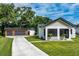Exterior of modern home showing a concrete driveway and detached two-car garage with attractive wood doors at 16615 Oklahoma St, Clermont, FL 34715