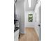 Hallway with wood floors features window, neutral colors, and modern lighting at 16615 Oklahoma St, Clermont, FL 34715