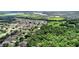 Panoramic aerial view displays property bordered by lush greenery, adjacent to neighborhood homes, and showcasing nature's embrace at 1702 Hoofprint Ct, Fruitland Park, FL 34731