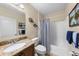 Bright bathroom with a granite-topped vanity, and a shower tub with a blue and white striped curtain at 1702 Hoofprint Ct, Fruitland Park, FL 34731