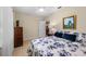 Comfortable bedroom with a ceiling fan, blue floral comforter, and an open door to another room at 1702 Hoofprint Ct, Fruitland Park, FL 34731
