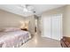 Neutral bedroom featuring a double bed, white closet and entry to the attached bathroom at 1702 Hoofprint Ct, Fruitland Park, FL 34731