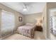 Well-lit bedroom featuring a ceiling fan, neutral walls, a decorative window treatment and attached bathroom at 1702 Hoofprint Ct, Fruitland Park, FL 34731
