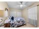 Bedroom with closet, fan and comfortable bedding with a floral comforter at 1702 Hoofprint Ct, Fruitland Park, FL 34731