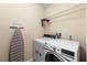 Laundry room featuring a front load washer and dryer with an ironing board at 1702 Hoofprint Ct, Fruitland Park, FL 34731