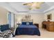 Cozy main bedroom with blue decor, a fan, and space for a workspace at 1702 Hoofprint Ct, Fruitland Park, FL 34731