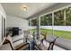 Screened in patio furnished with a glass table and four chairs plus a grill at 1702 Hoofprint Ct, Fruitland Park, FL 34731