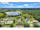 A high-angle view showing homes near a lush green landscape and lake, offering a serene neighborhood setting at 1892 Sanderling Dr, Clermont, FL 34711