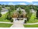 Aerial view of a well-maintained home, lush lawns and mature palms in a serene neighborhood at 1892 Sanderling Dr, Clermont, FL 34711