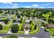 An aerial view showcases the property within a quiet, residential neighborhood with mature trees and landscaping at 1892 Sanderling Dr, Clermont, FL 34711