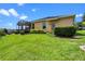 Well-maintained backyard showcasing the home's exterior, screened porch and landscaped yard with manicured bushes at 1892 Sanderling Dr, Clermont, FL 34711