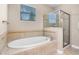 Bright bathroom featuring a soaking tub, glass shower, and a window that provides natural light at 1892 Sanderling Dr, Clermont, FL 34711
