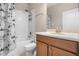 Cozy bathroom showcasing a vanity, toilet, and a tub-shower combo with a decorative curtain at 1892 Sanderling Dr, Clermont, FL 34711