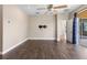 Bedroom with dark hardwood floors, a ceiling fan, and an open door to the patio at 1892 Sanderling Dr, Clermont, FL 34711