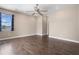 Well-lit bedroom with neutral walls, dark hardwood floors, and a ceiling fan at 1892 Sanderling Dr, Clermont, FL 34711