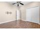 Bedroom offers a comfortable setting with hardwood flooring, ceiling fan, and a closet for storage at 1892 Sanderling Dr, Clermont, FL 34711