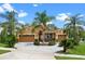 Charming home featuring a three-car garage and a lush yard with mature palm trees at 1892 Sanderling Dr, Clermont, FL 34711