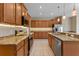 The kitchen boasts stainless steel appliances, wooden cabinets, granite countertops and under cabinet lighting at 1892 Sanderling Dr, Clermont, FL 34711