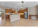Open kitchen featuring granite countertops, stainless steel appliances, wooden cabinets, and pendant lights at 1892 Sanderling Dr, Clermont, FL 34711