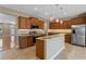 A modern kitchen features stainless steel appliances, wood cabinets, and granite countertops at 1892 Sanderling Dr, Clermont, FL 34711