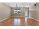 Large living room with wood floors, ceiling fan, a large window and entry to outdoor space at 1892 Sanderling Dr, Clermont, FL 34711