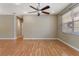 Living room with wood laminate floors, a ceiling fan and a window providing plenty of natural light at 1892 Sanderling Dr, Clermont, FL 34711