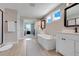 Elegant bathroom with a soaking tub, double vanities, and natural light at 2161 Gold Dust Dr, Minneola, FL 34715
