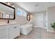 Bright bathroom featuring a soaking tub, double sinks, and modern fixtures at 2161 Gold Dust Dr, Minneola, FL 34715
