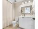 Bright bathroom with white cabinets, a large mirror, and a shower curtain at 2161 Gold Dust Dr, Minneola, FL 34715