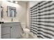 A bathroom featuring striped shower curtain, a toilet, sink and mirror at 2161 Gold Dust Dr, Minneola, FL 34715