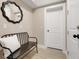Hallway features tile floors, a mirror, a bench and a white door at 2161 Gold Dust Dr, Minneola, FL 34715