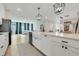 Contemporary kitchen with stainless steel appliances, white cabinets, an island, and an open view of the living room at 2161 Gold Dust Dr, Minneola, FL 34715