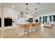 Open-concept kitchen featuring white cabinetry, a center island with barstools, and seamless flow to the living area at 2161 Gold Dust Dr, Minneola, FL 34715